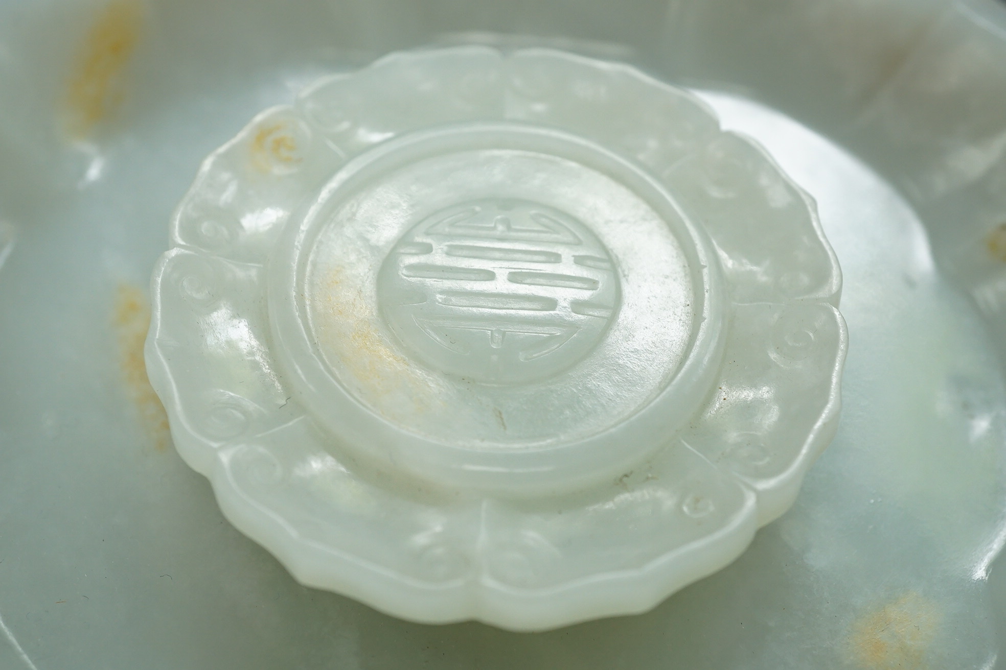 A Chinese white and russet jade petal lobed cup stand